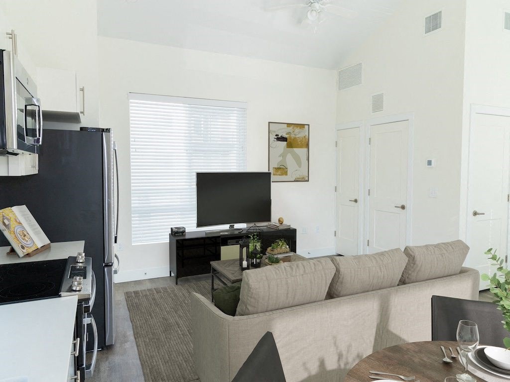 Living Room with a Couch and TV at The Arza Apartments