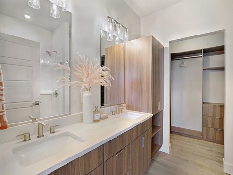 A bathroom with a white sink and gold faucets.