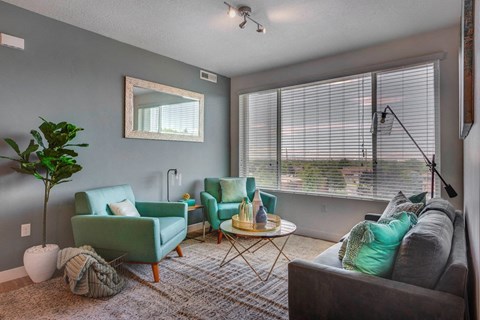 a living room with a couch and chairs and a large window