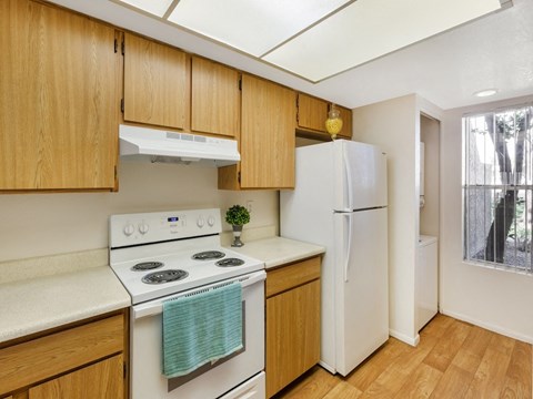 a kitchen with white appliances and wooden cabinets