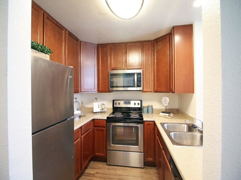 a kitchen with stainless steel appliances and wooden cabinets