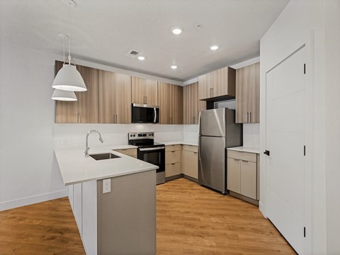 A modern kitchen with wooden cabinets and stainless steel appliances.