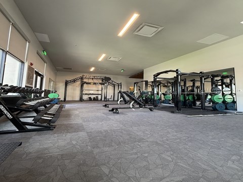 A gym with a variety of equipment including weights and machines.