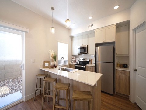 a kitchen with a large island and a stainless steel refrigerator