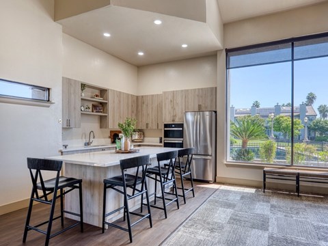 A kitchen with a table and chairs and a window overlooking a city.