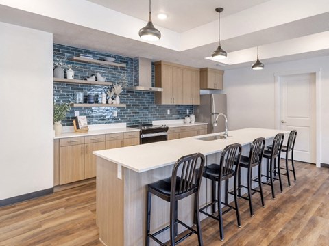 A kitchen with a white counter top and black bar stools.