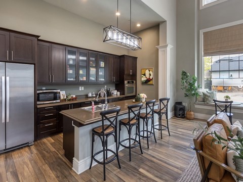 A kitchen with dark wood cabinets and a stainless steel refrigerator.