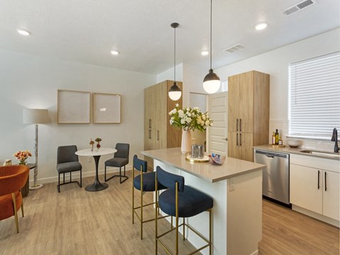 an open kitchen and dining area with a table and chairs and a refrigerator