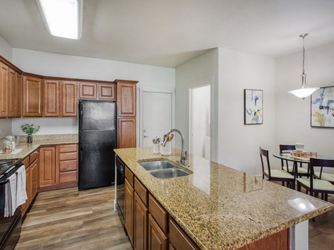 A kitchen with wooden cabinets and a granite countertop.