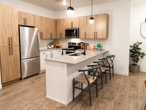 a kitchen with a large island and a stainless steel refrigerator