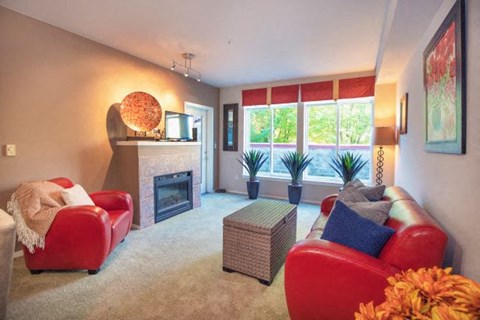 a living room with a red couch and a fireplace
