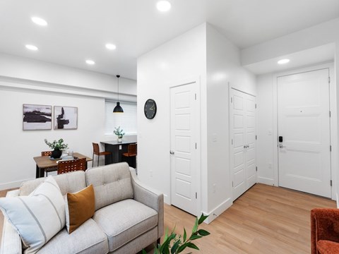 A living room with a grey couch and a wooden floor.