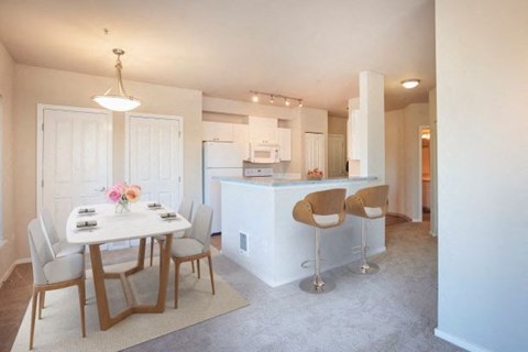 a kitchen and dining room with a white table and chairs