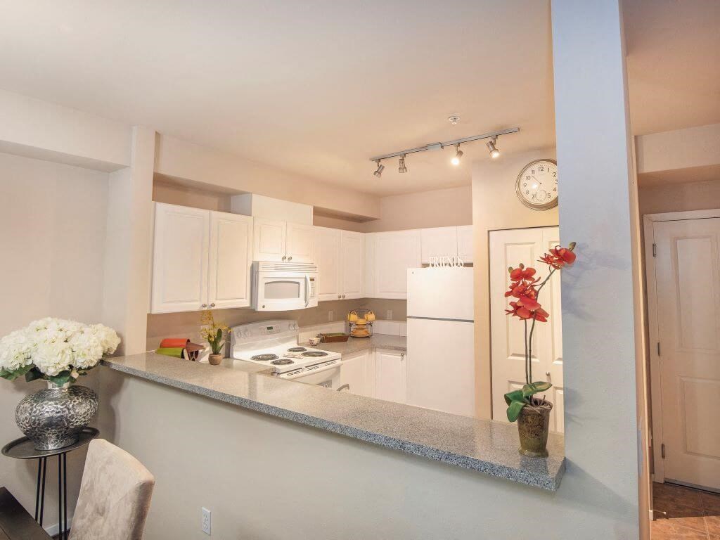 Open kitchen with updated white appliances at Metropolitan Collection Apartments, Washington, 98057