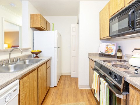 a kitchen with a stove sink and microwave and a refrigerator