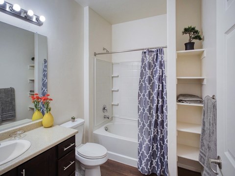 A bathroom with a white toilet, a sink, a bathtub, and a shower curtain.