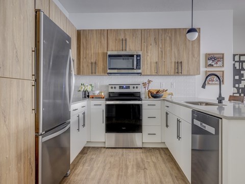 A modern kitchen with wooden cabinets and stainless steel appliances.