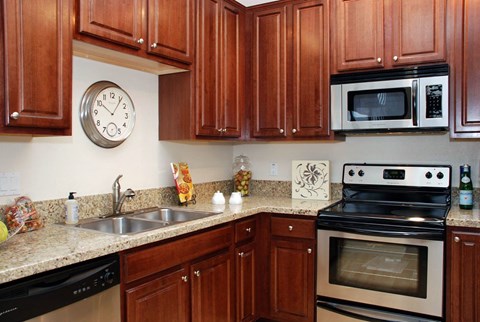 a kitchen with wood cabinets and a clock on the wall