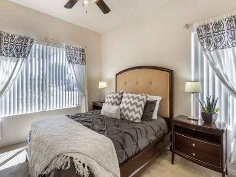 A bedroom with a large bed and a ceiling fan.