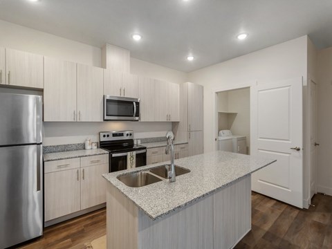 A kitchen with white cabinets and a granite countertop.