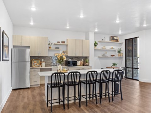 A kitchen with a table and chairs in the foreground and a refrigerator in the background.