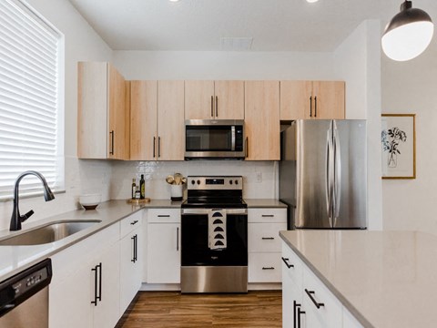a kitchen with white cabinets and stainless steel appliances