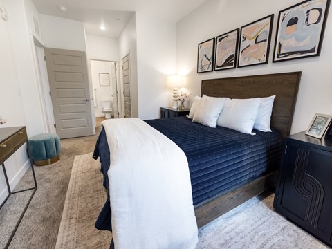 A bedroom with a large bed and a painting on the wall.