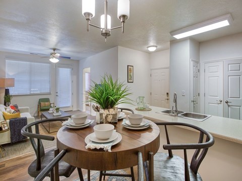 A dining room with a wooden table set for two.