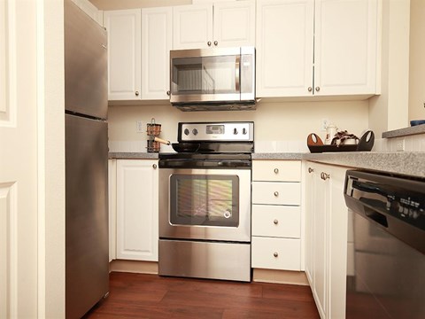 a kitchen with stainless steel appliances and white cabinets