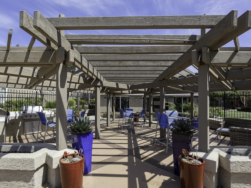 a patio with tables and chairs and a pergola