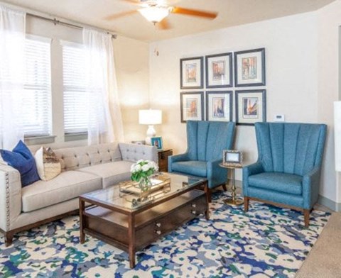 a living room with blue chairs and a white couch