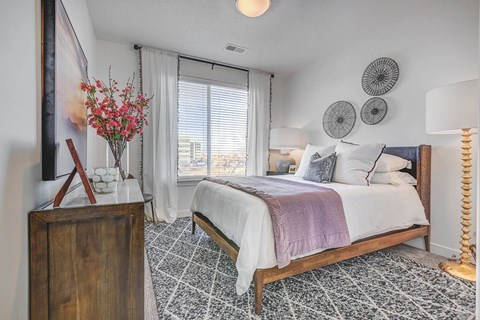 A bedroom with a large bed and a wooden dresser.