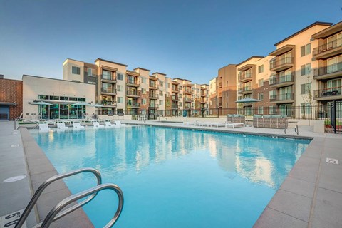 A large swimming pool in front of apartment buildings.