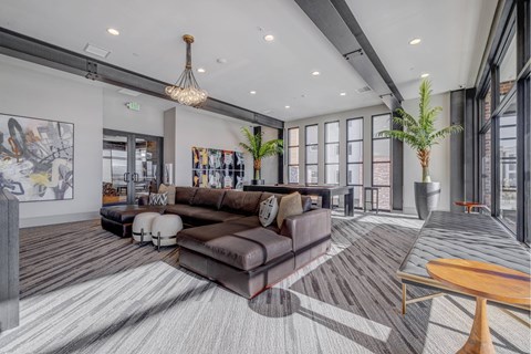 A modern living room with a large brown couch and a wooden coffee table.