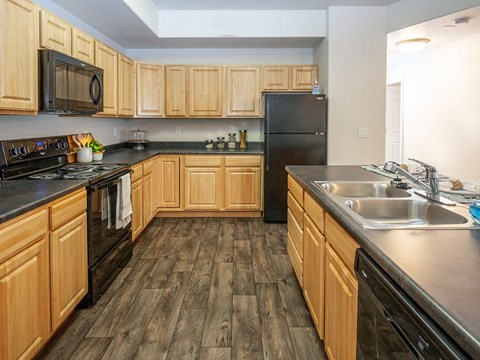 a kitchen with wooden cabinets and black appliances
