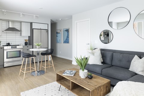 a living room with a couch and a table and a kitchen
