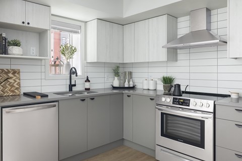 a kitchen with white cabinets and a stove and a sink