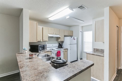 A kitchen with a granite countertop and white appliances.