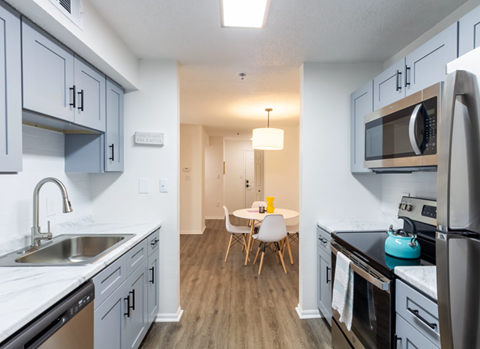 A kitchen with a white sink and a black refrigerator.