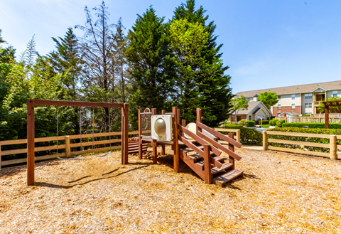 A playground with a slide and a wooden structure.