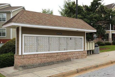 A small building with a brown roof and a sign that says "Bellhop's Den" is in front of a house.