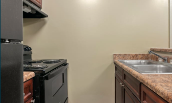 A kitchen with a black stove and a granite countertop.