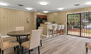 A dining room with a table and chairs.
