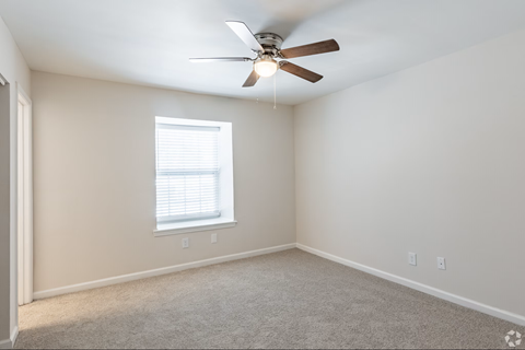 A room with a ceiling fan and a window.