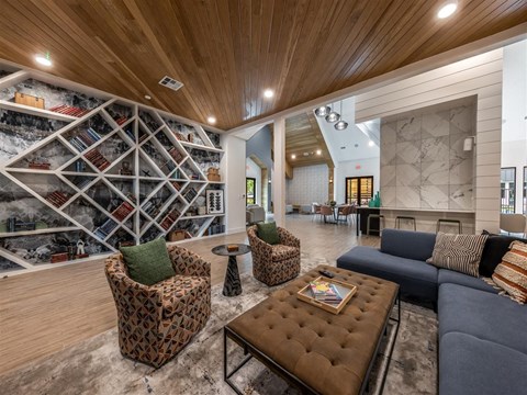 a living room with couches and chairs and a wall of wine racks