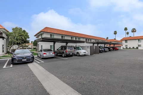 A parking lot with cars and a building in the background.