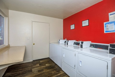 A laundry room with a red wall and a white door.