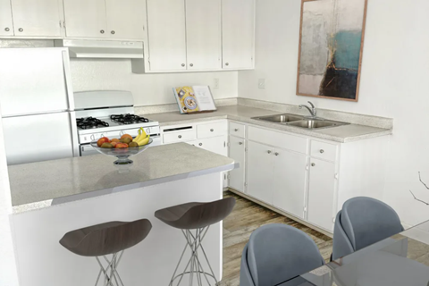 A kitchen with white cabinets and a white fridge.