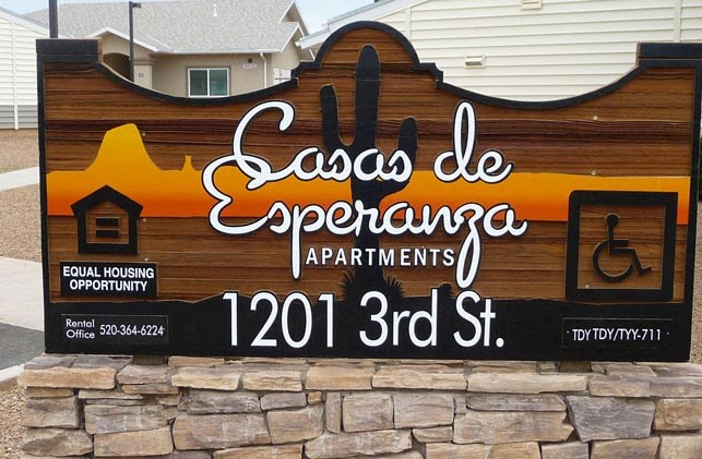 a sign in front of a building with a cactus on it