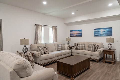 A living room with a white couch and a wooden coffee table.
